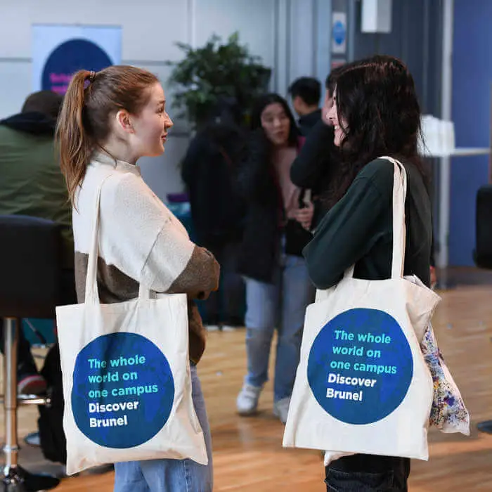 two students with Brunel University London tote bags