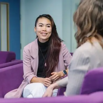 female-student-in-conversation-with-another-student-700x700px