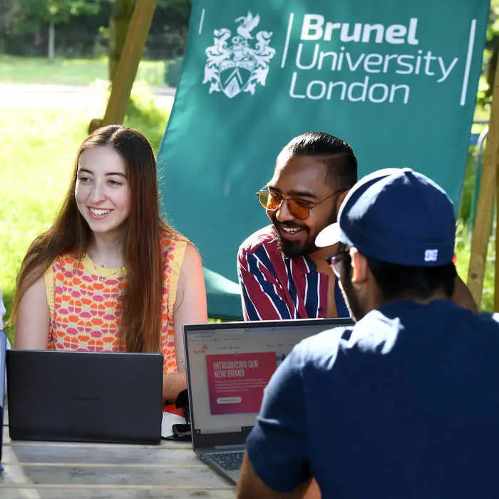 group-of-students-sitting-outside-on-campus-with-laptops-700x700