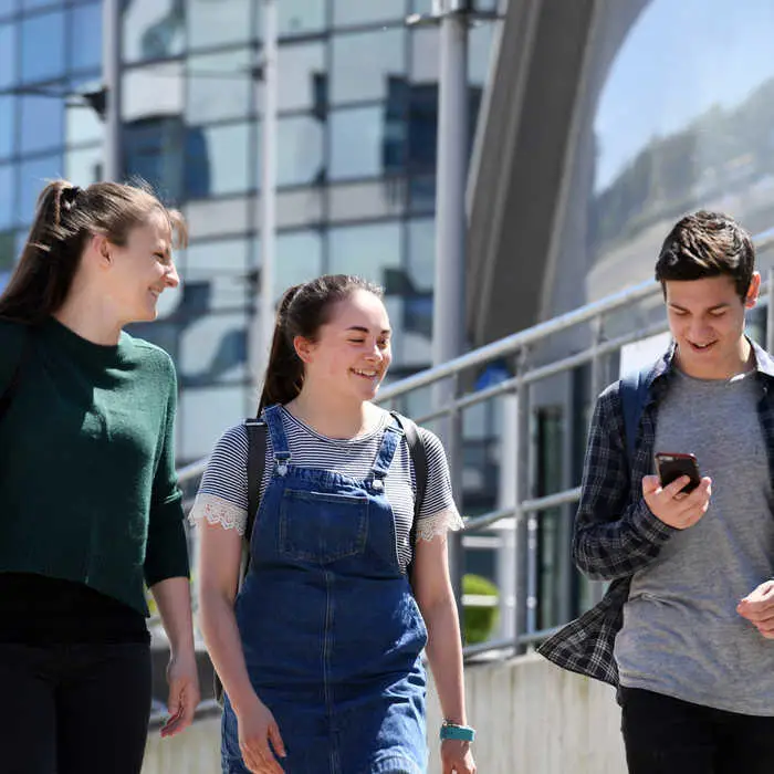 three-students-walking-on-campus