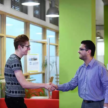 An Economics and Finance student shakes a staff member's hand at the Professional Development Centre