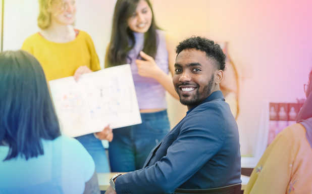 student smiling into the camera in a workshop