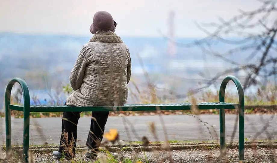 Envato-old-woman-sitting-on-bench-in-autumn-city-park-920