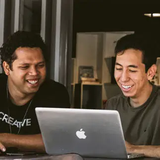 two-men looking at a macbook