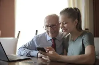 older man and young woman looking at tablet