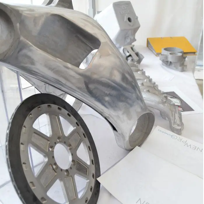 Partially assembled metal car wheel and metal components on a table.