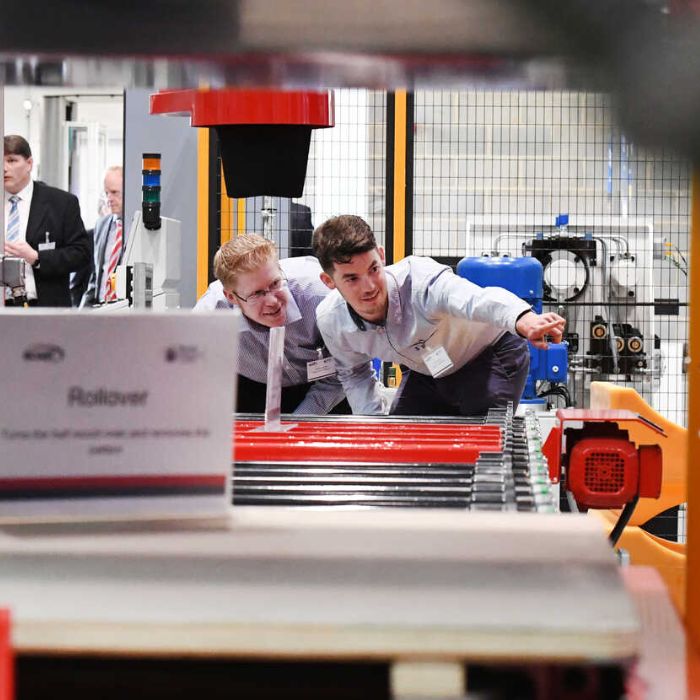 BCAST researchers inspecting machinery at an industrial laboratory with conveyor belts and equipment.