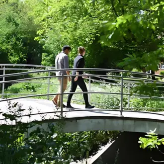 two students walking across the campus bridge